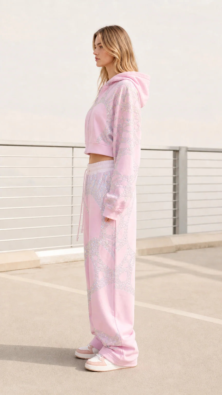 Side view of model wearing pastel pink cropped hoodie and baggy sweatpants
