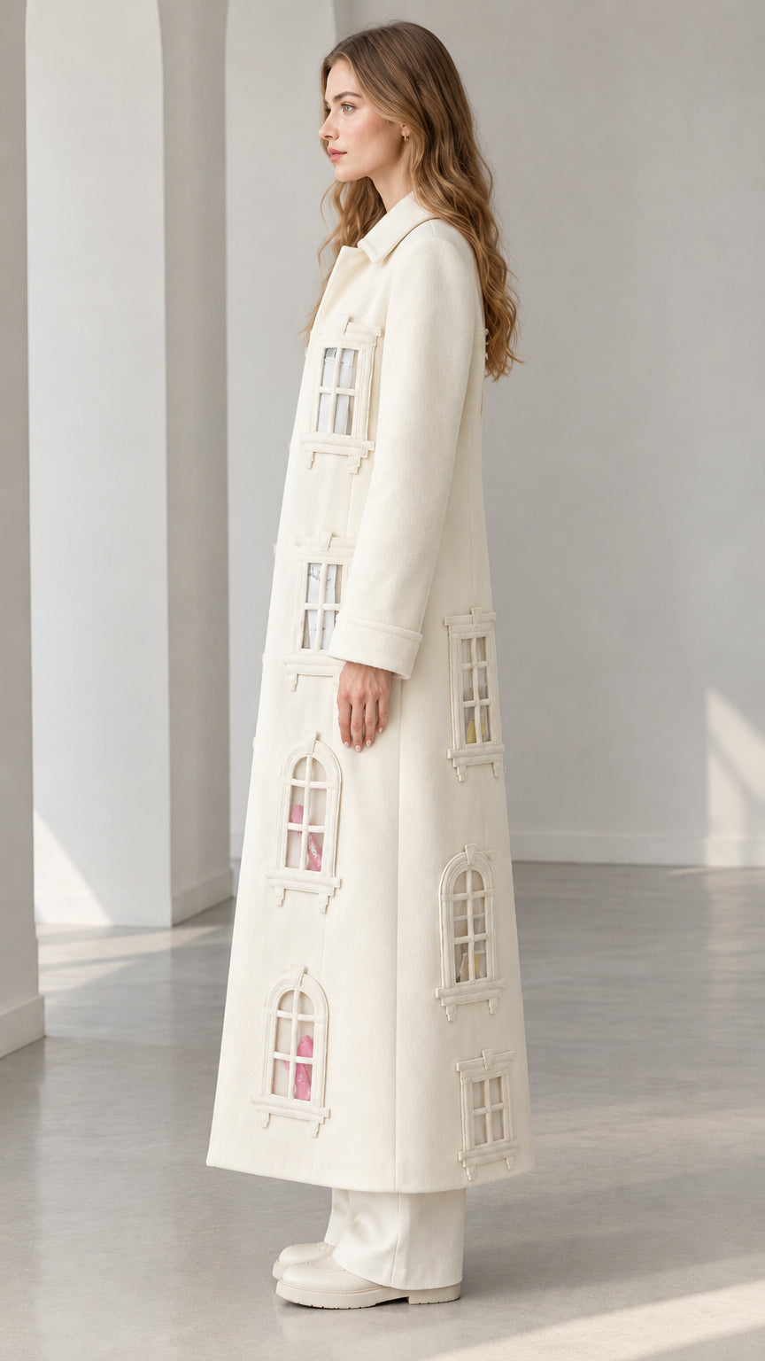 Side profile view of ivory window appliqué long overcoat