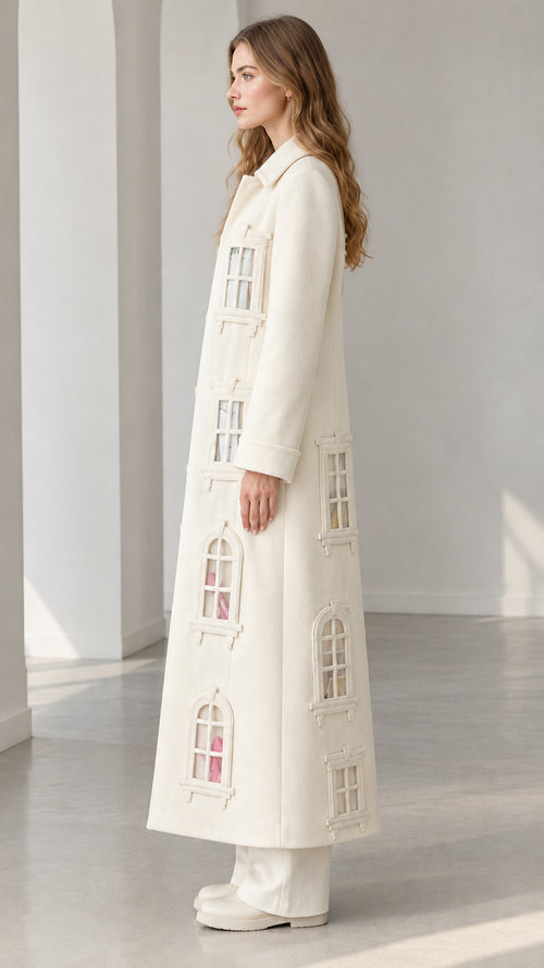 Side profile view of ivory window appliqué long overcoat