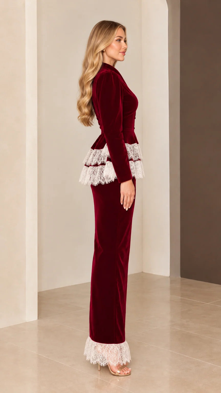 Side profile view of burgundy velvet long-sleeve maxi gown with tiered lace waist and hem