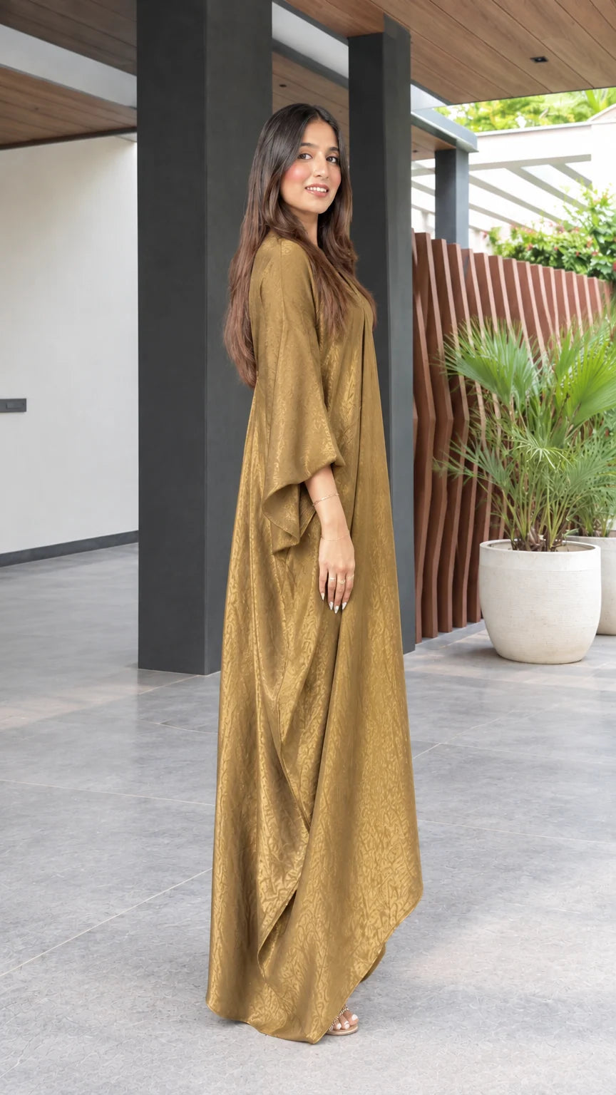 Side profile view of model wearing a flowy gold textured kaftan maxi gown