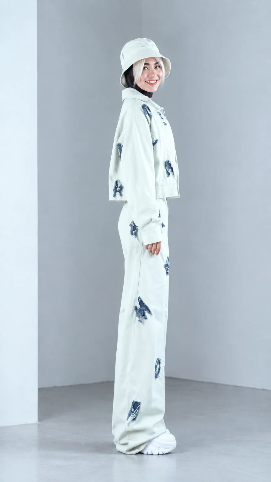 Side view of woman posing in mint green two-piece jacket and wide-leg streetwear set