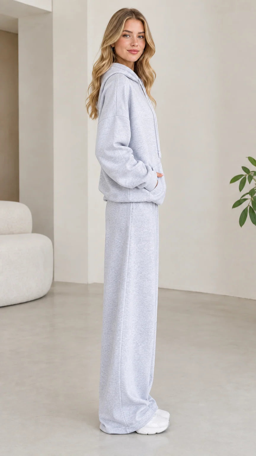 Side profile of model wearing light grey hoodie and wide leg sweatpants set