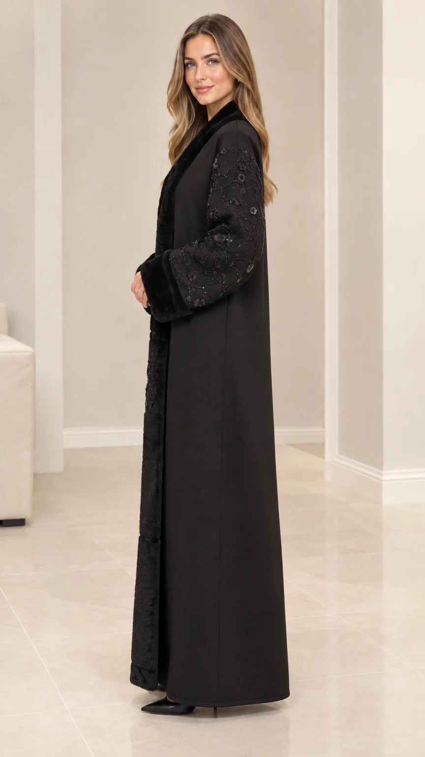 Side profile view of elegant black long coat with plush fur trim and embellished sleeves
