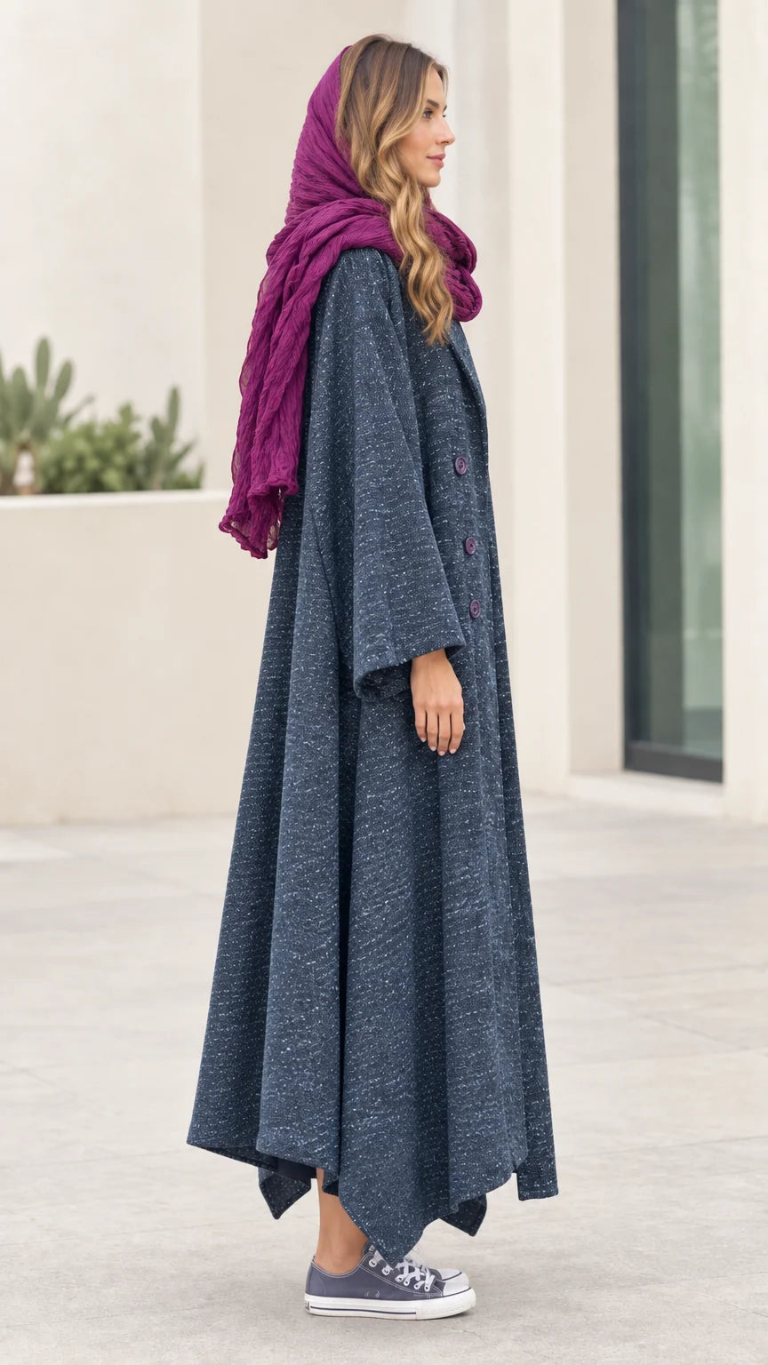 Side profile view of woman modeling Slate Blue asymmetric longline coat