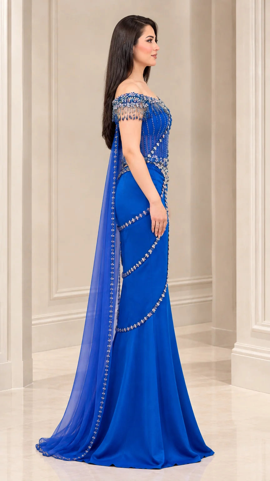 Side angle of model wearing Royal Blue embellished corset formal gown with flowing cape