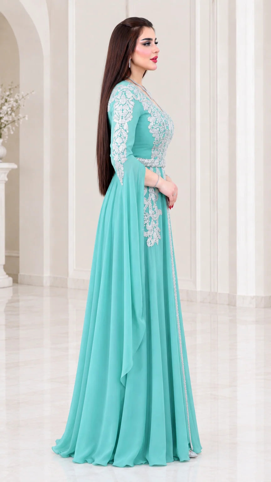 Side profile view of aqua embroidered cape sleeve evening gown