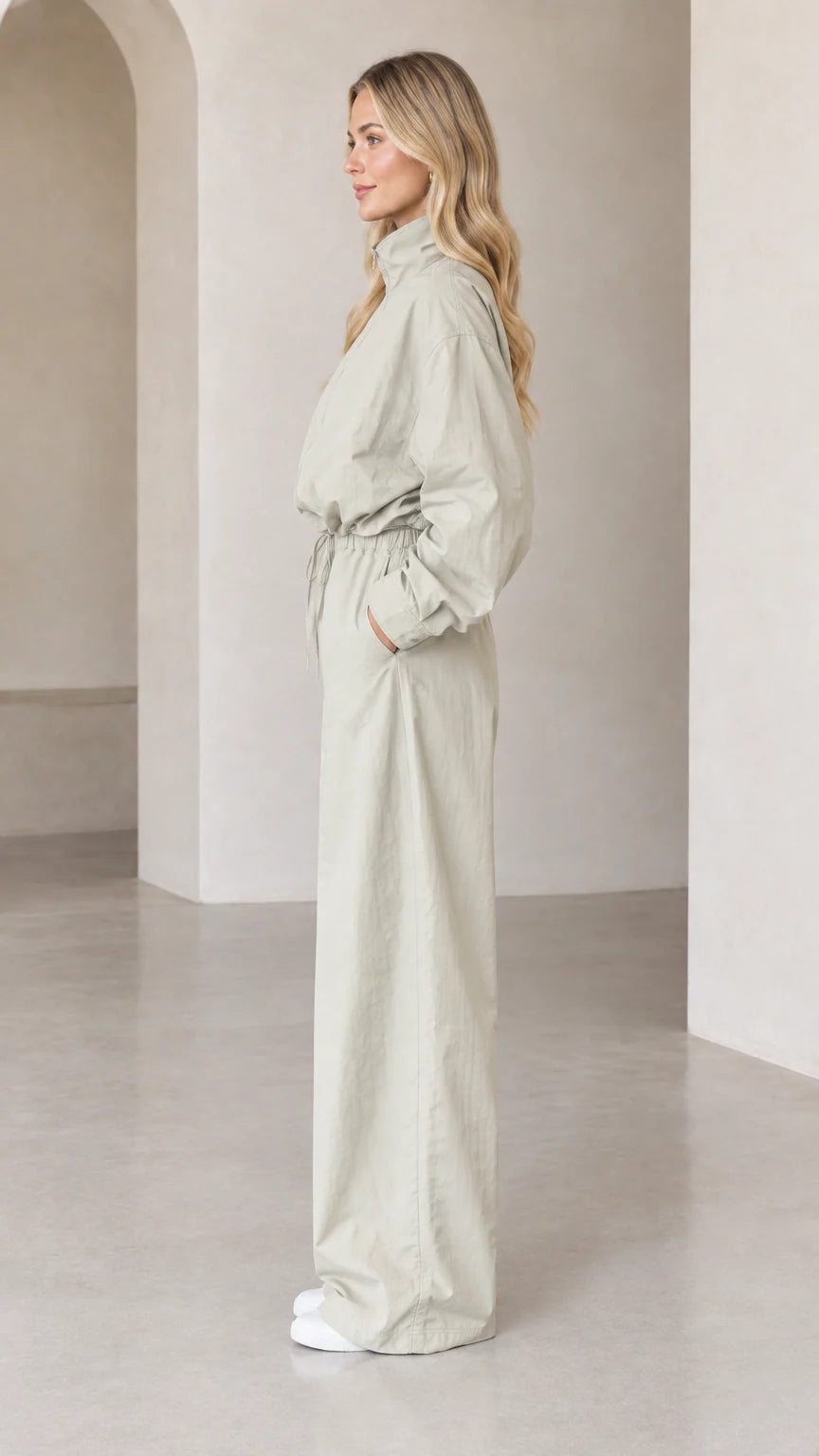Side profile view of woman wearing Light Sage relaxed-fit utility jumpsuit