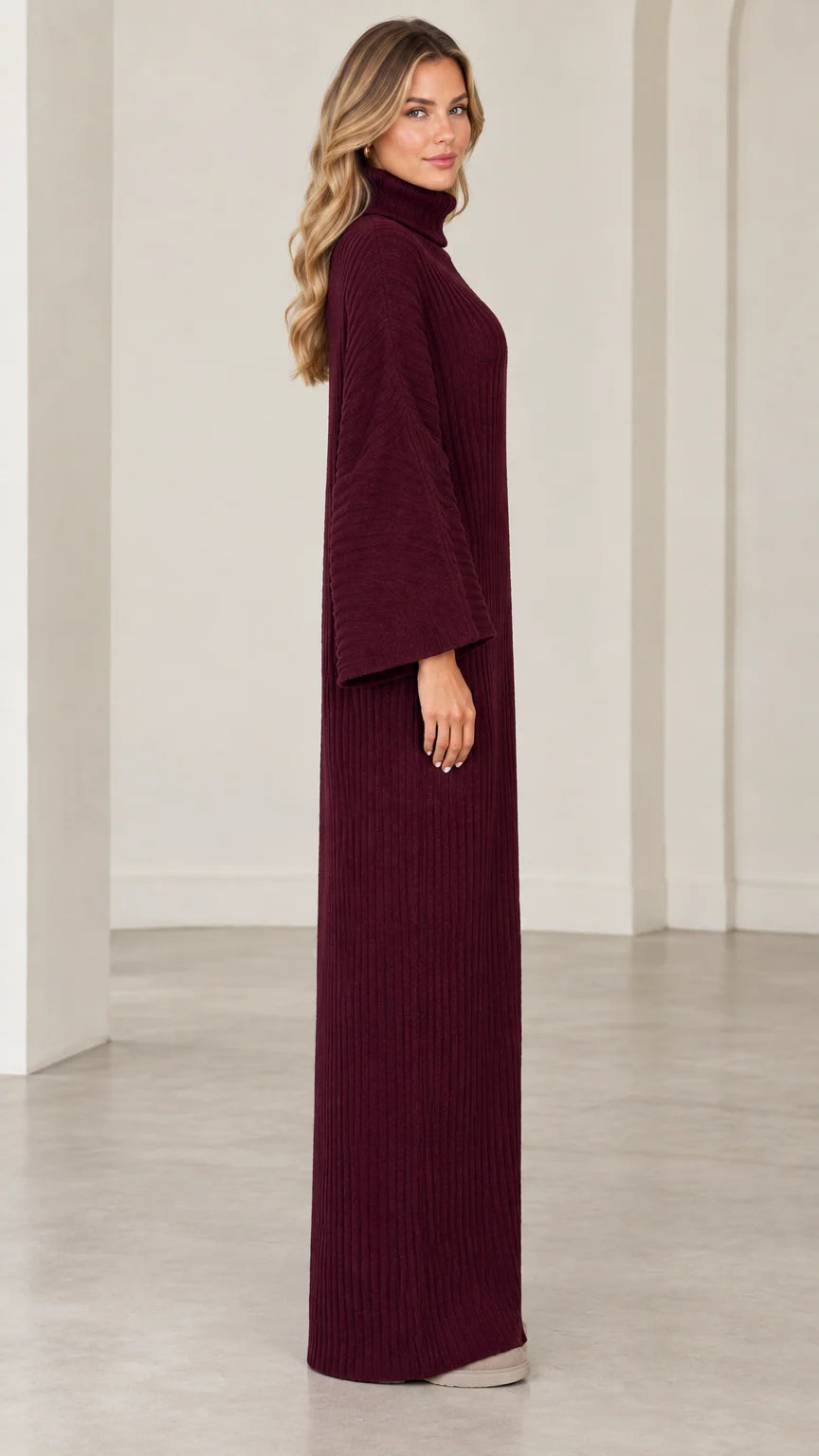 Side profile view of model wearing burgundy ribbed maxi dress