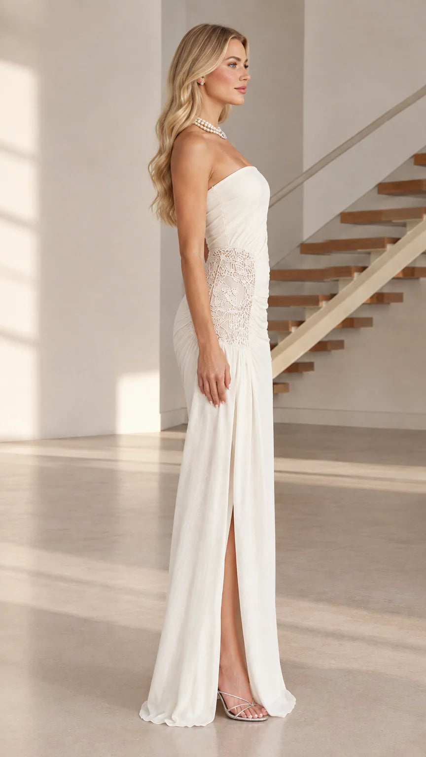 Side profile of white strapless evening gown showing leg slit and lace detail