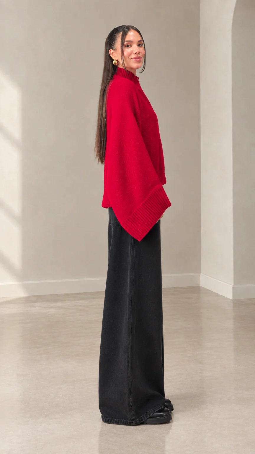 Side view of woman wearing red batwing sleeve knit sweater