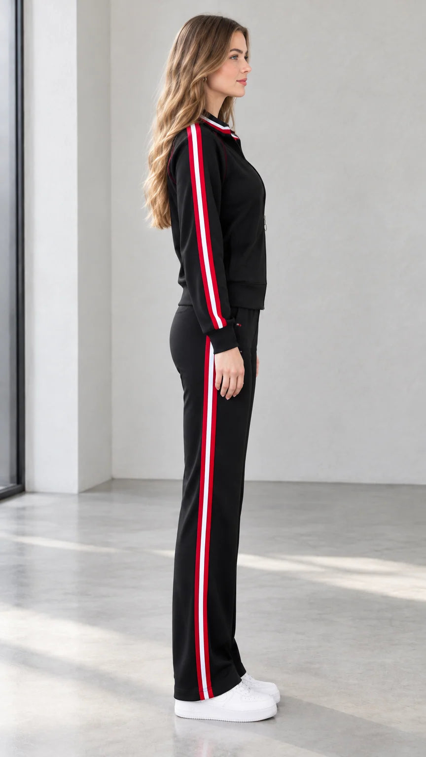 Side profile view of black zip jacket and side-striped track pants set