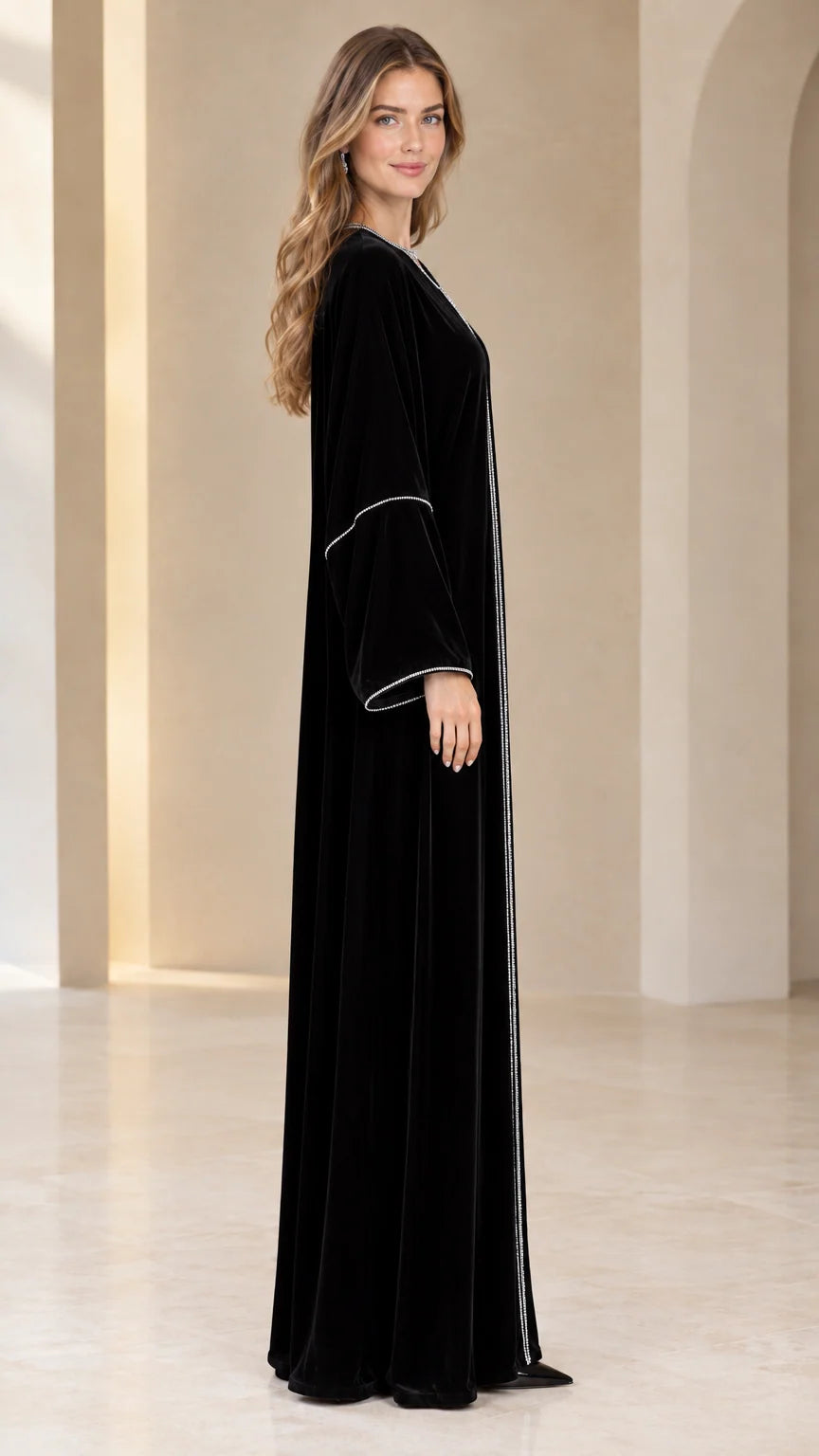 Side profile view of elegant black velvet long-sleeve maxi dress