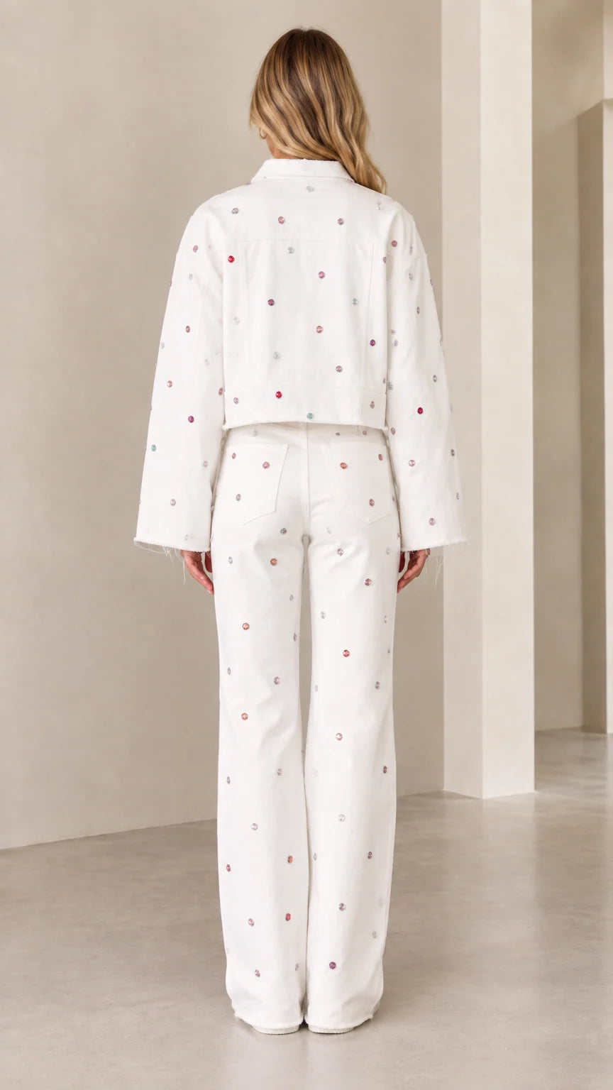 Back view of woman wearing white embellished cropped jacket and wide-leg trousers