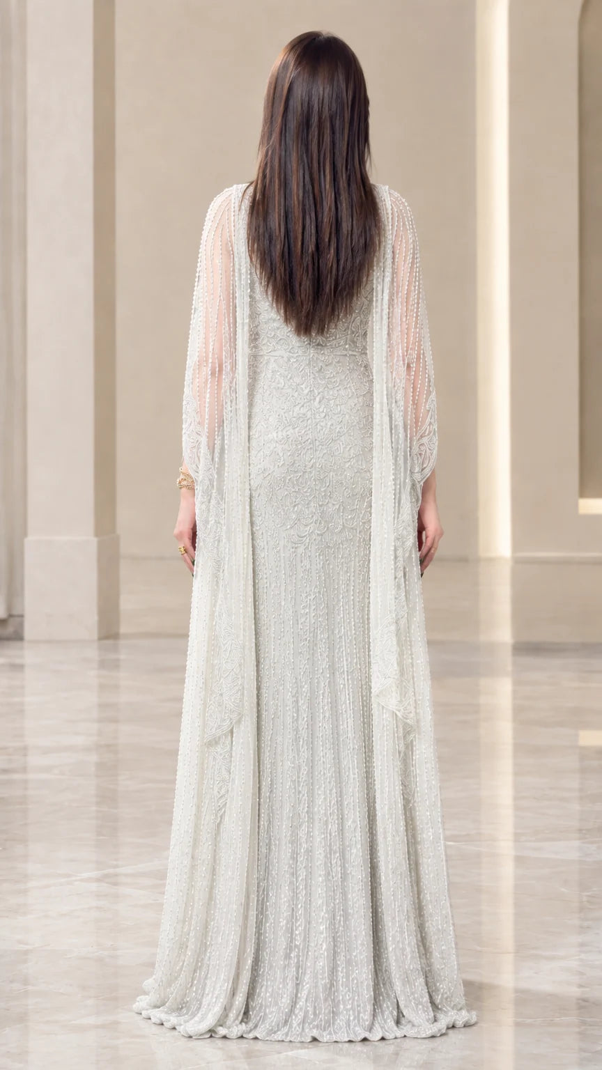 Back view of silver sequin embellished cape gown showing sweeping hem