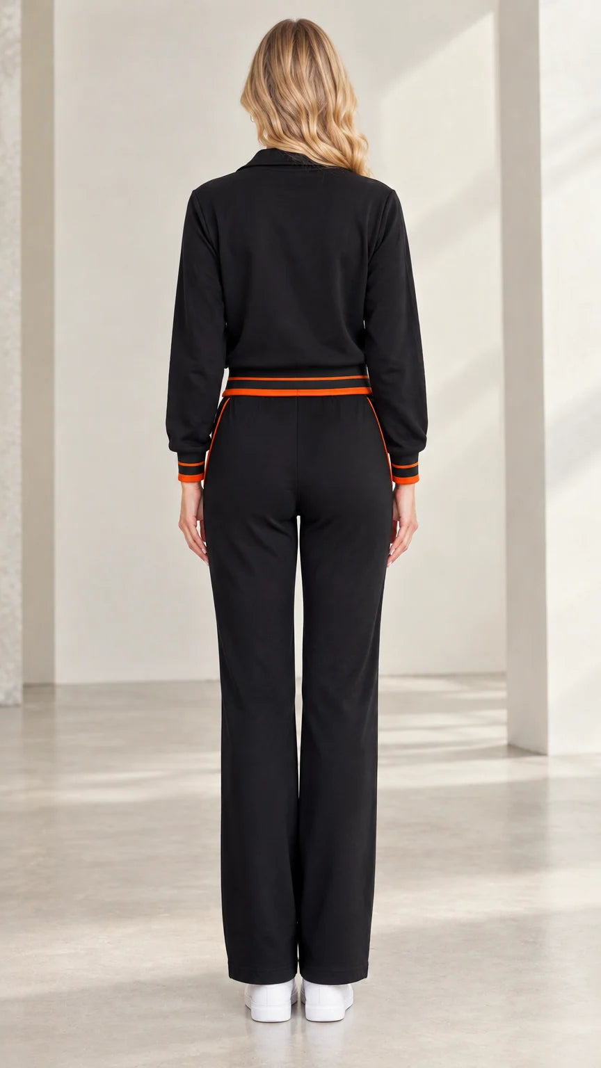 Back view of woman wearing black zip-up tracksuit with straight wide legs