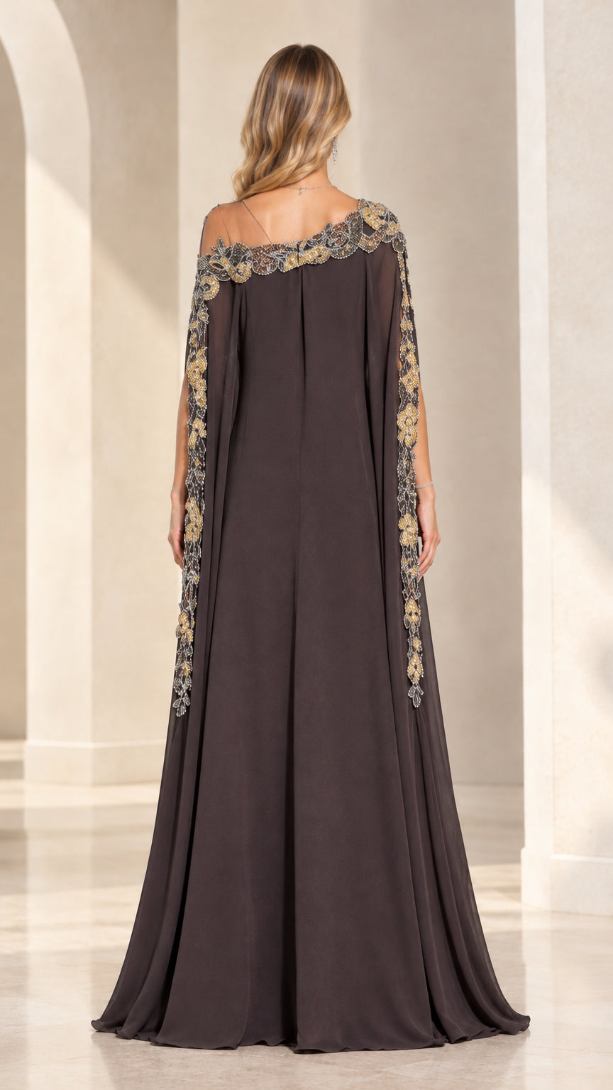 Back view of model wearing Dark Brown Cape Evening Gown with delicate sheer shoulder detailing