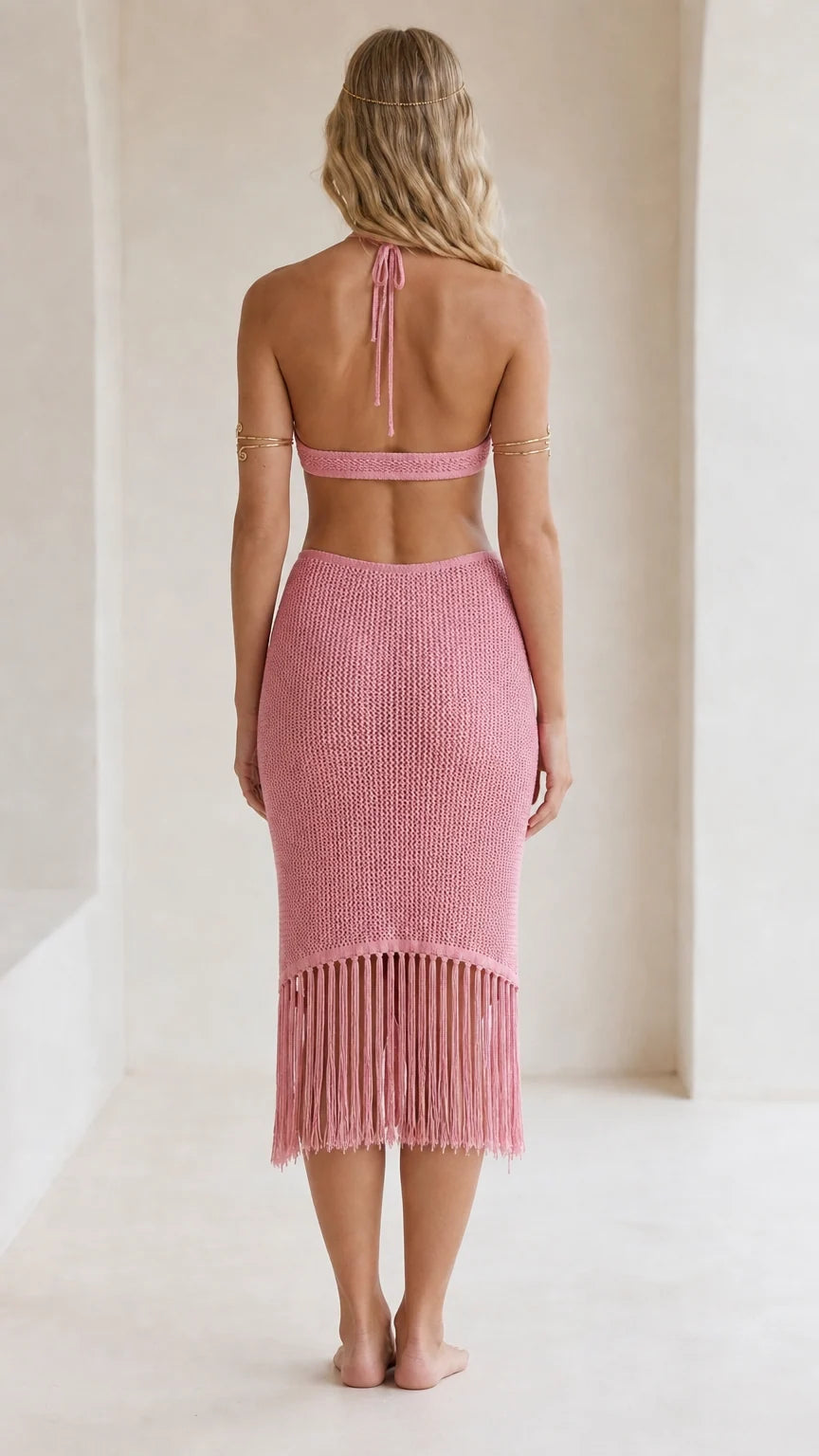 Back view of model showing open back design of pink fringe knit dress