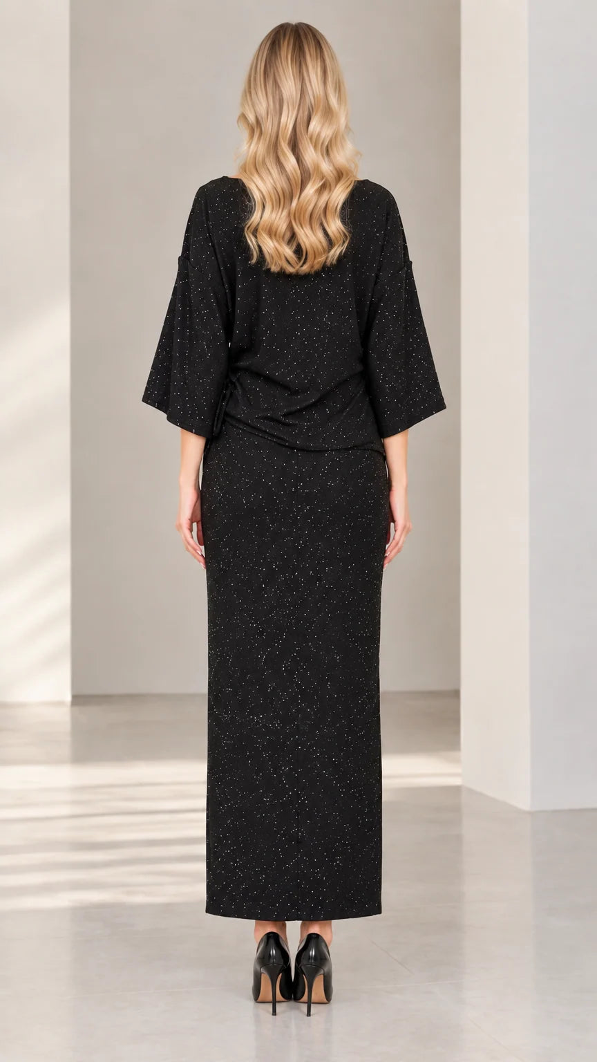 Back view of woman wearing elegant black shimmer long skirt and blouse set