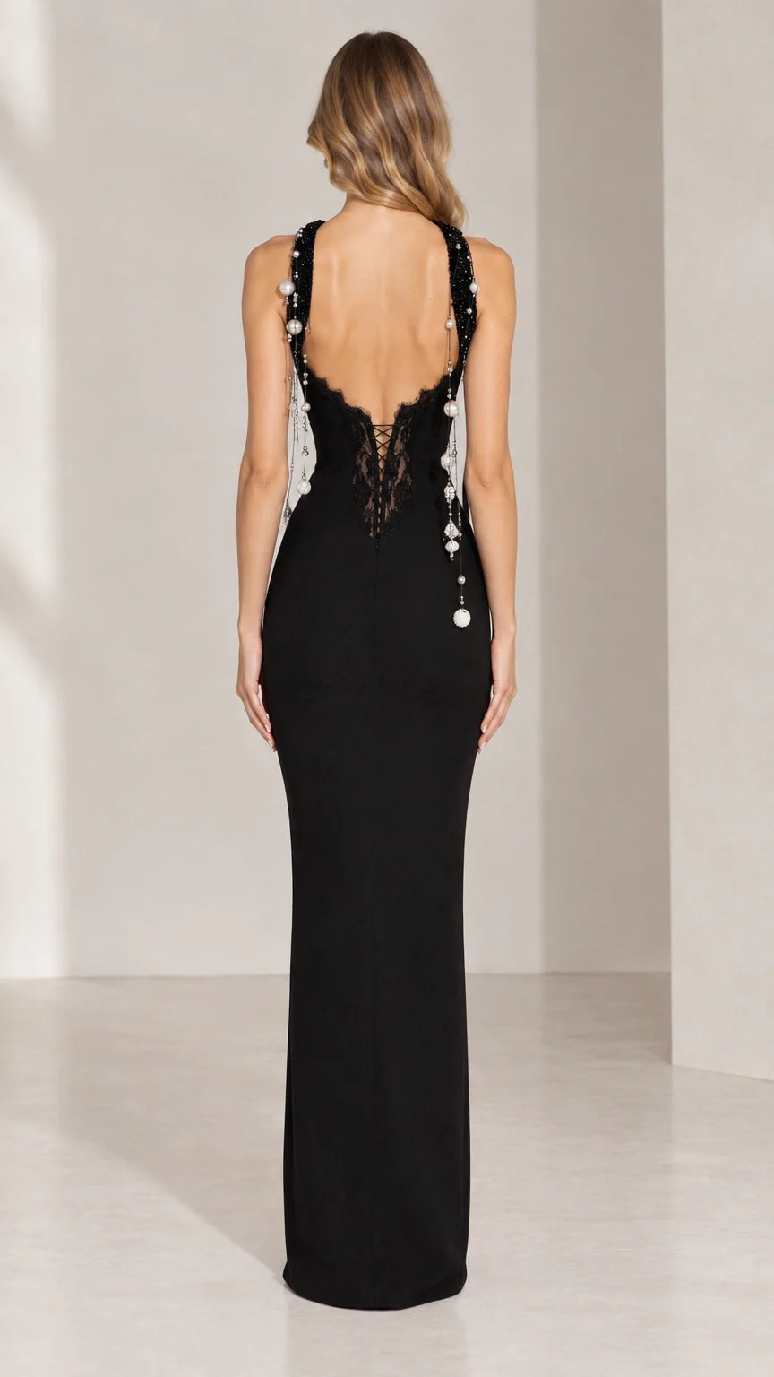 Back view of black formal dress featuring open back with lace trim and beaded strands
