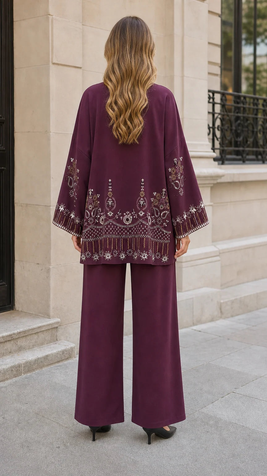 Back view of plum cardigan showing detailed embroidery on hemline and sleeves