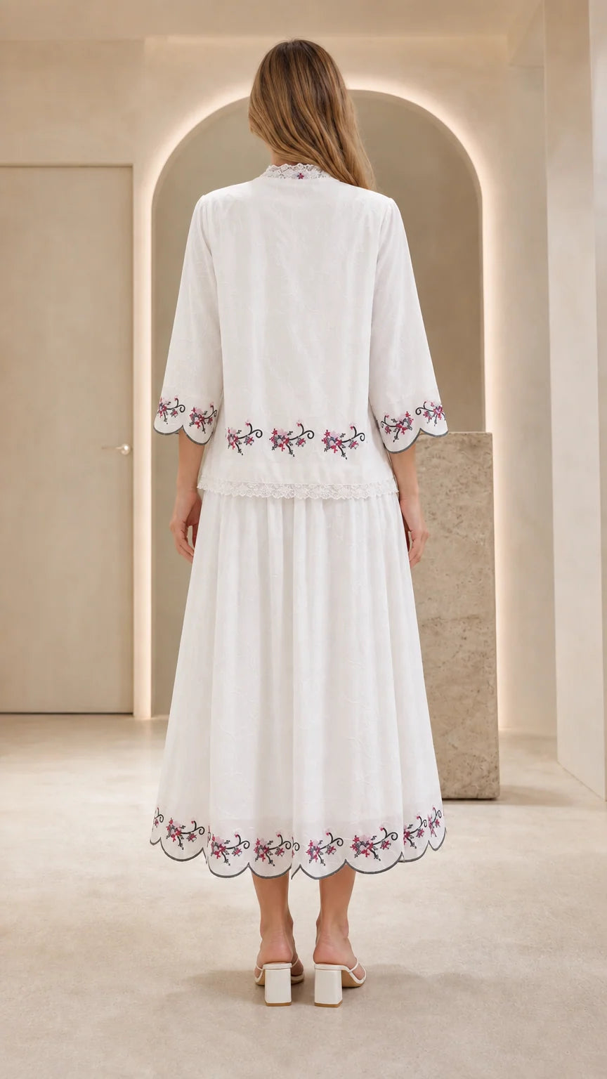 Back view of model showing embroidered details on white dress set