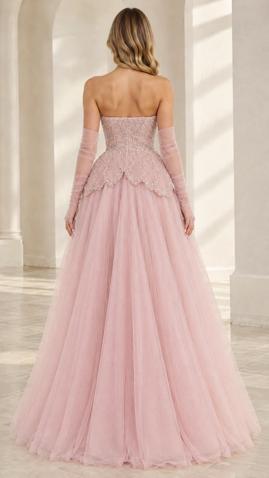 Back view of Blush Pink strapless gown with fitted bodice and flowing tulle skirt