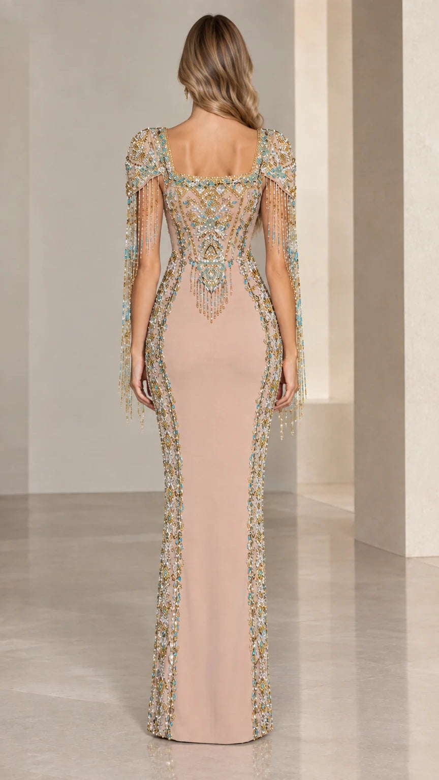 Back view of model in Nude embellished evening gown showcasing back beadwork and fringe details