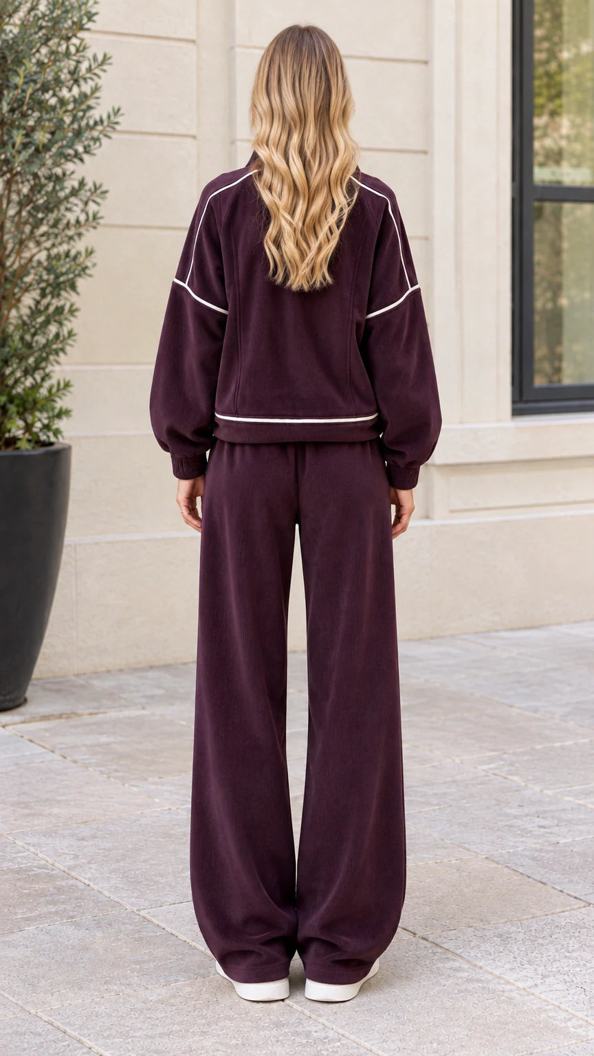 Back view of woman wearing burgundy zip-up jacket and wide leg pants