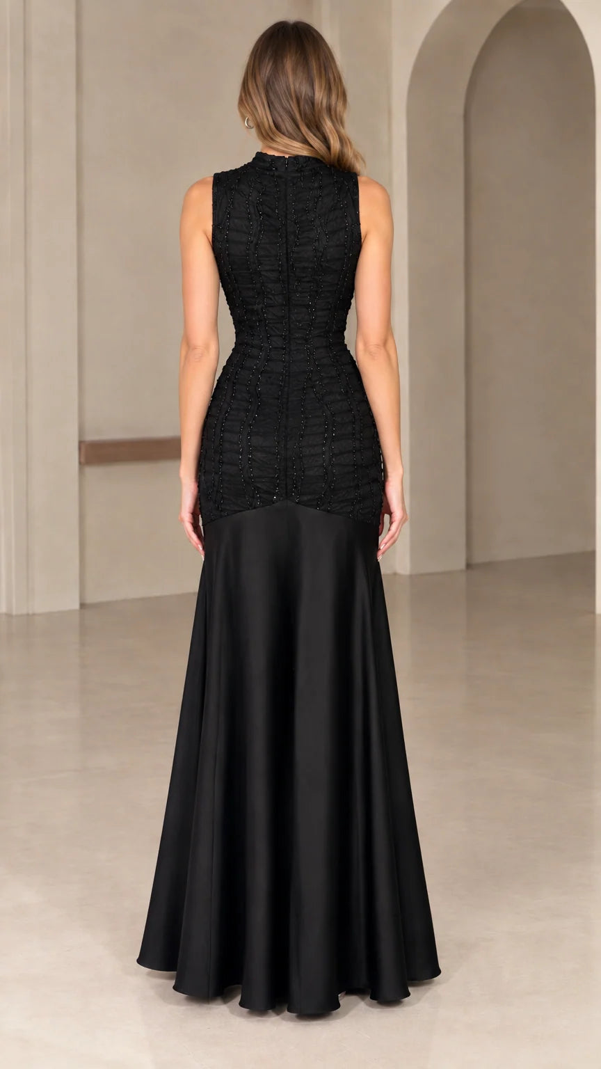 Back view of black high neck drop-waist evening dress with flared satin skirt