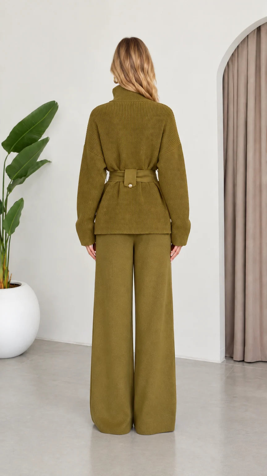 Back view of model wearing the Olive Green ribbed knit sweater and wide-leg pants