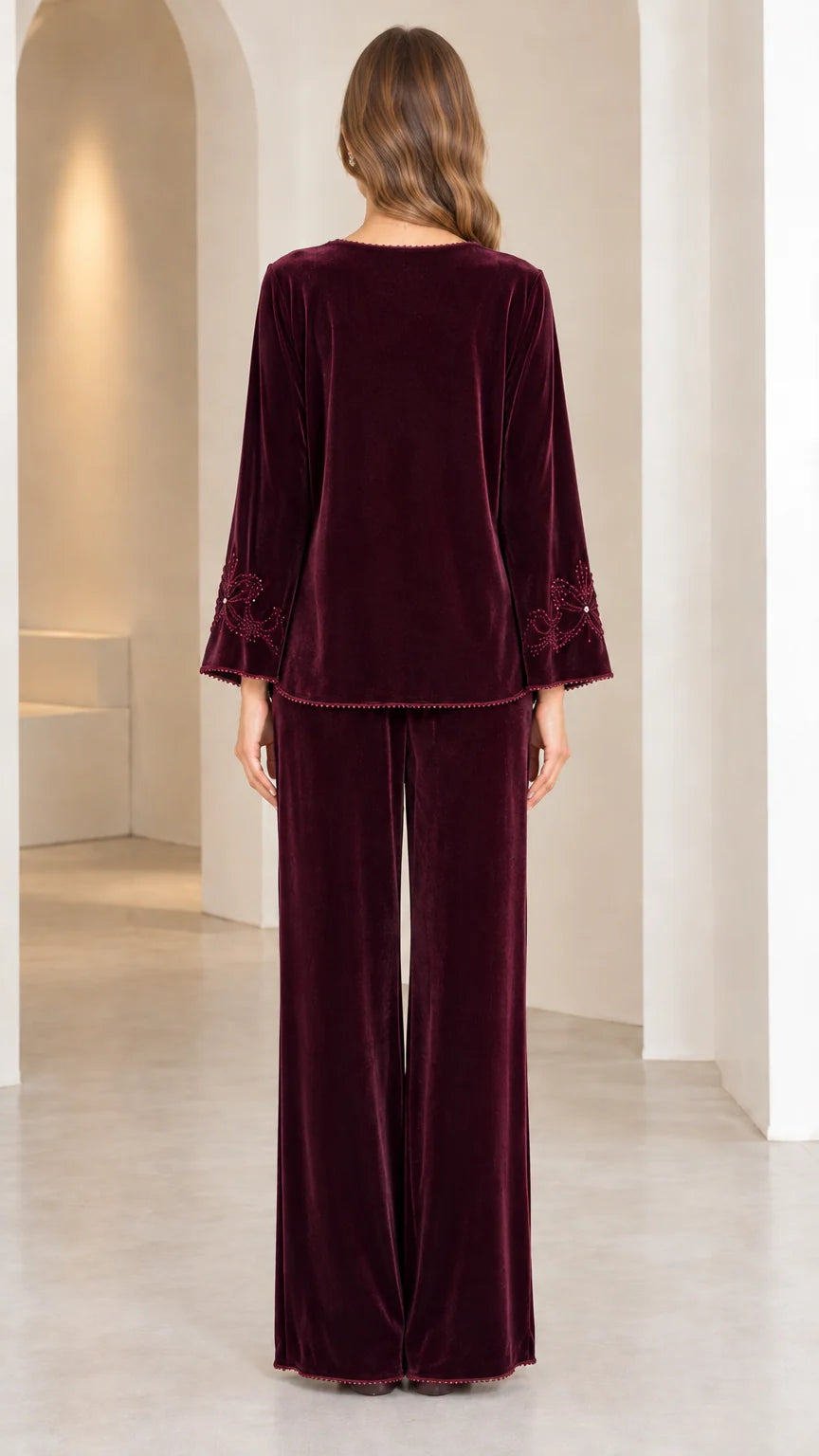 Back view of model in Burgundy velvet long-sleeve top and wide-leg trousers