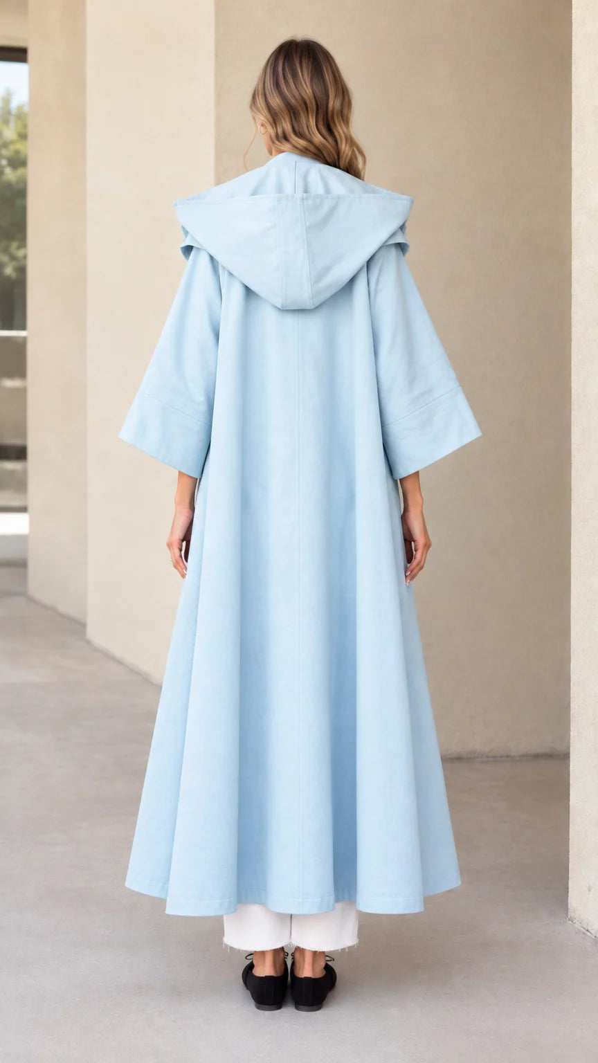 Back view of sky blue hooded maxi swing coat showing hood and full sweep