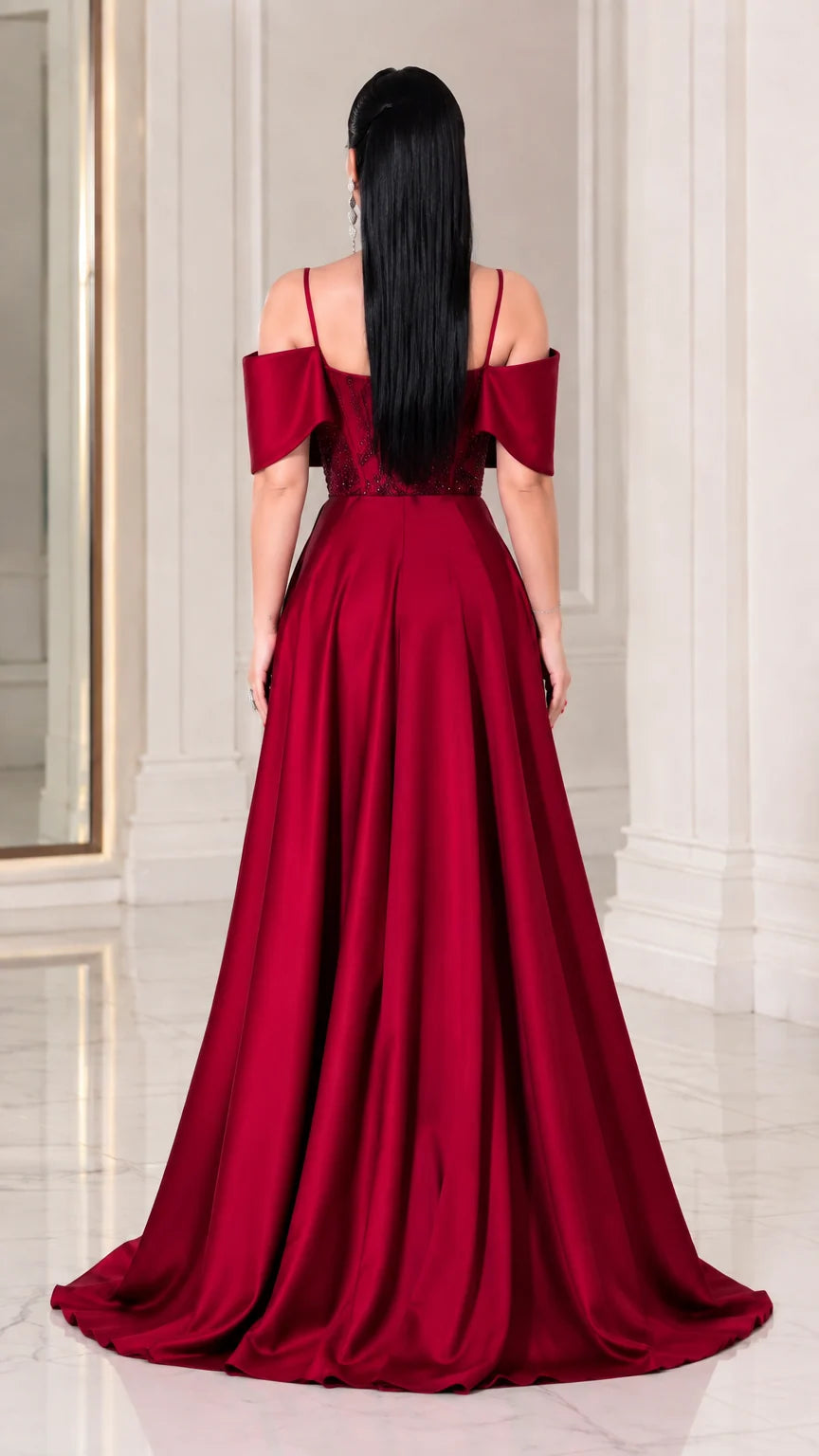 Back view of model showing the flowing satin-finish overskirt and cold-shoulder back design in Wine Red