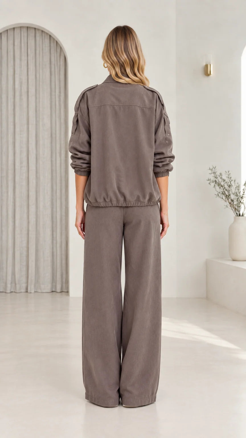Back view of model in taupe utility jacket and matching wide-leg trousers