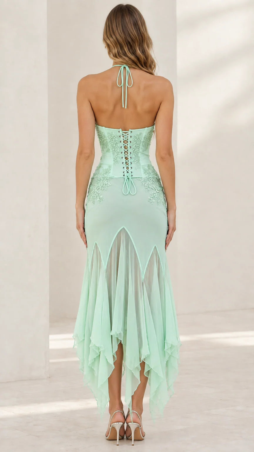 Back view of mint green dress highlighting halter tie and lace-up corset back