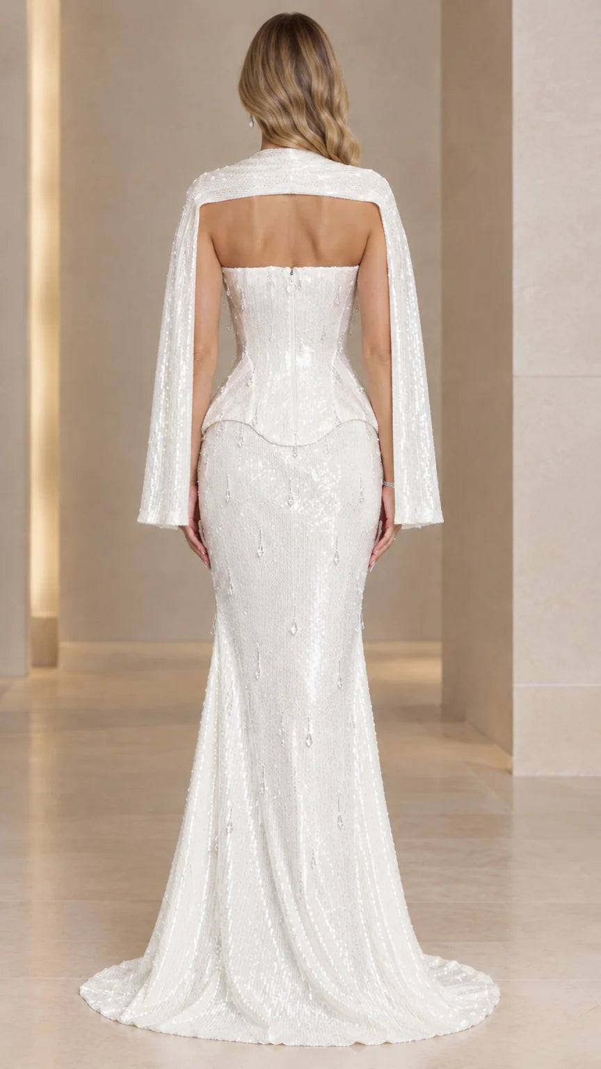 Back view of white strapless sequin mermaid evening gown showing back cutout and train