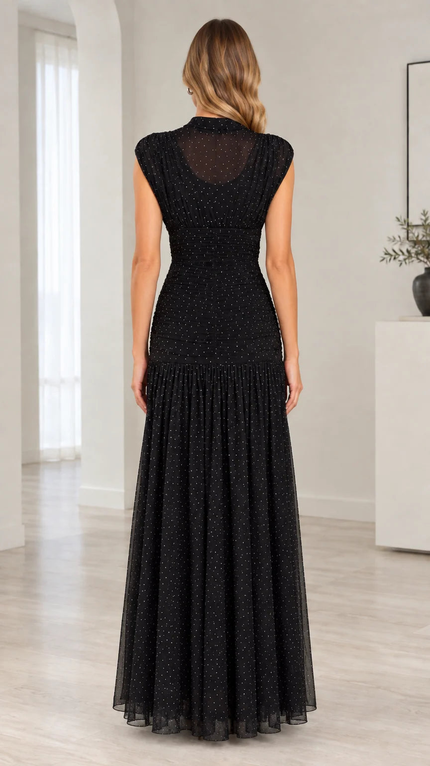 Back view of model wearing black ruched bodice sheer mesh maxi dress
