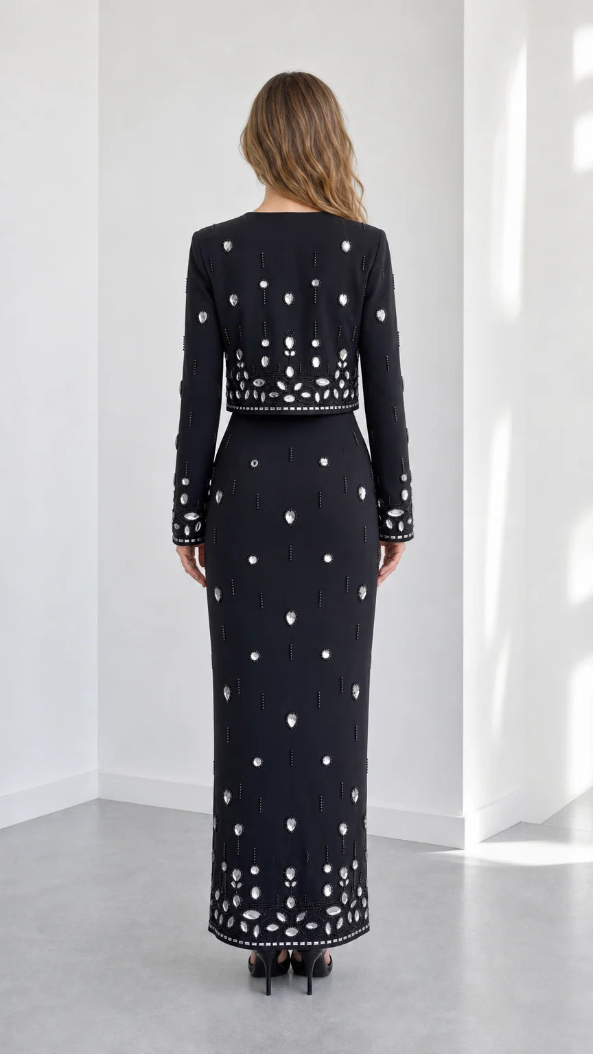 Back view of black rhinestone embellished two-piece evening set showing column skirt