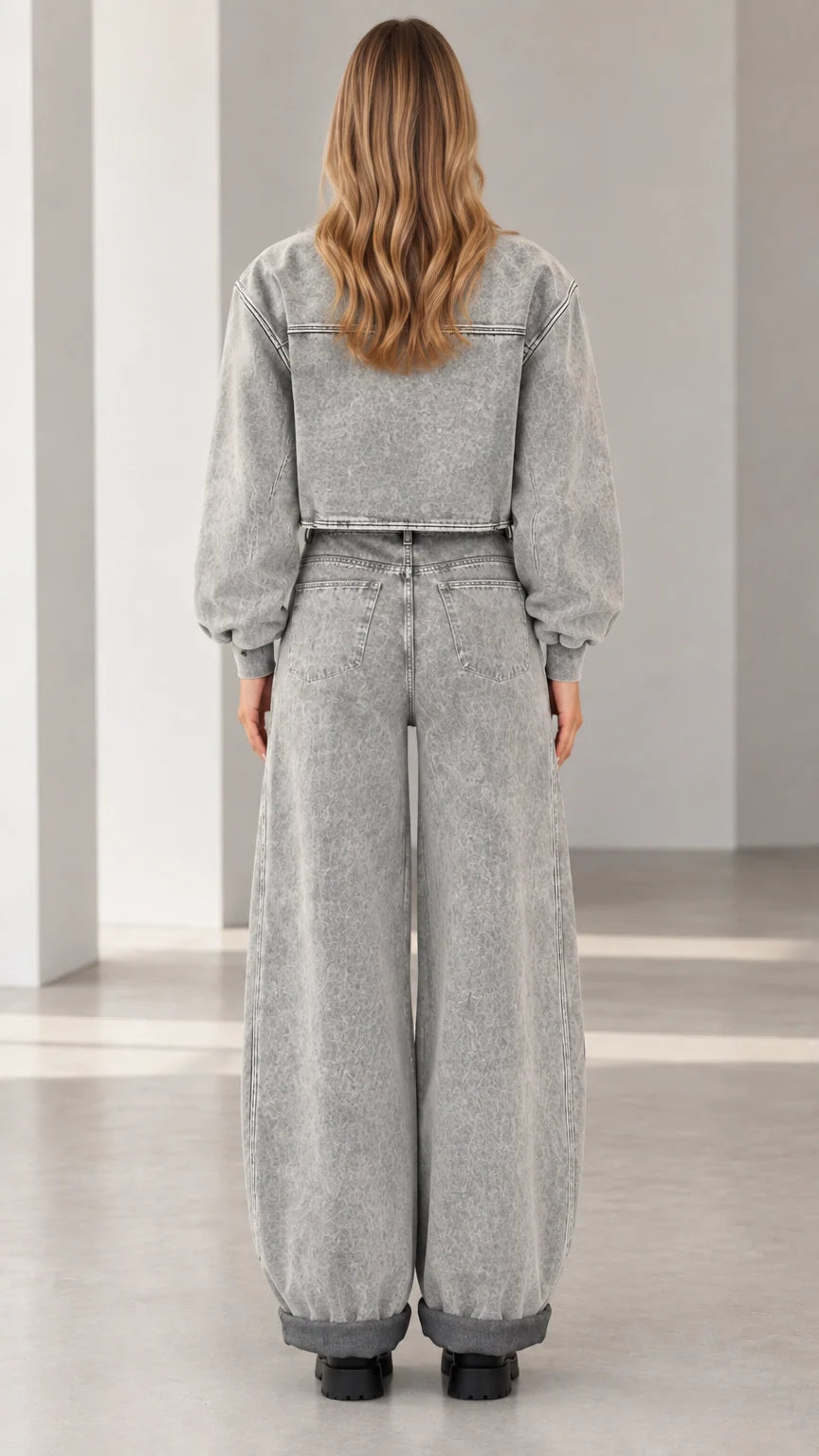 Back view of model wearing grey mineral wash cropped bomber and wide leg denim set
