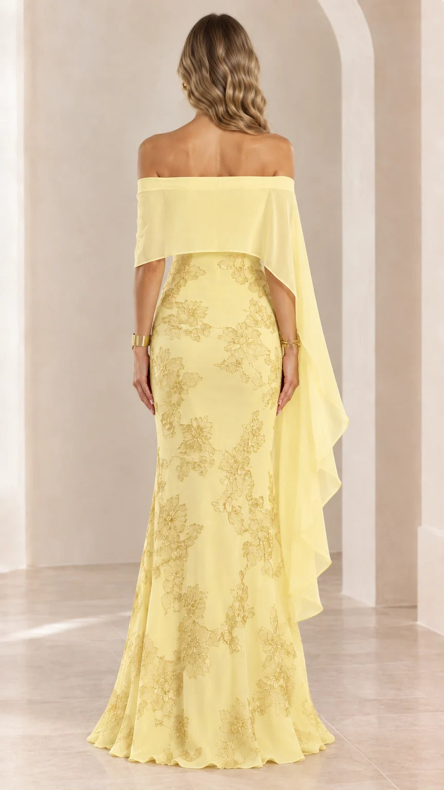 Back view of woman wearing yellow off-the-shoulder cape evening gown