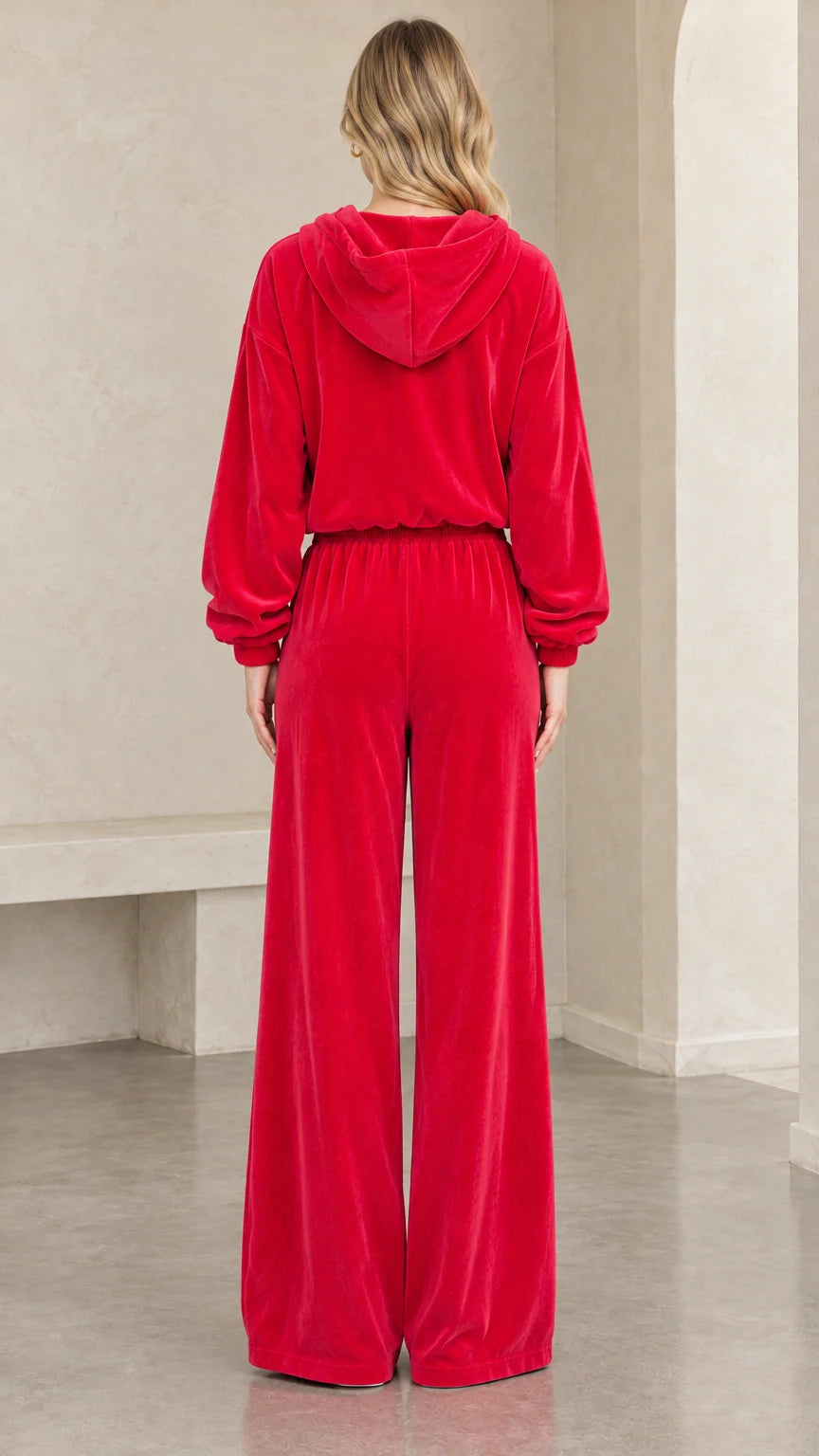 Back view of woman wearing red velour hoodie and wide leg sweatpants