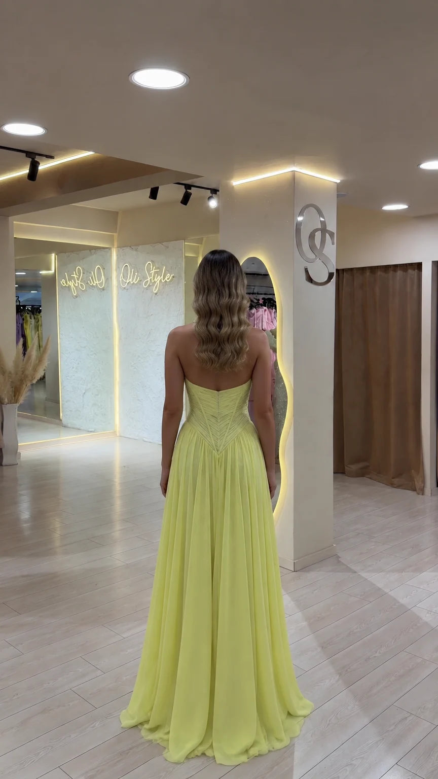 Back view of model in yellow halter open-back floor-length gown