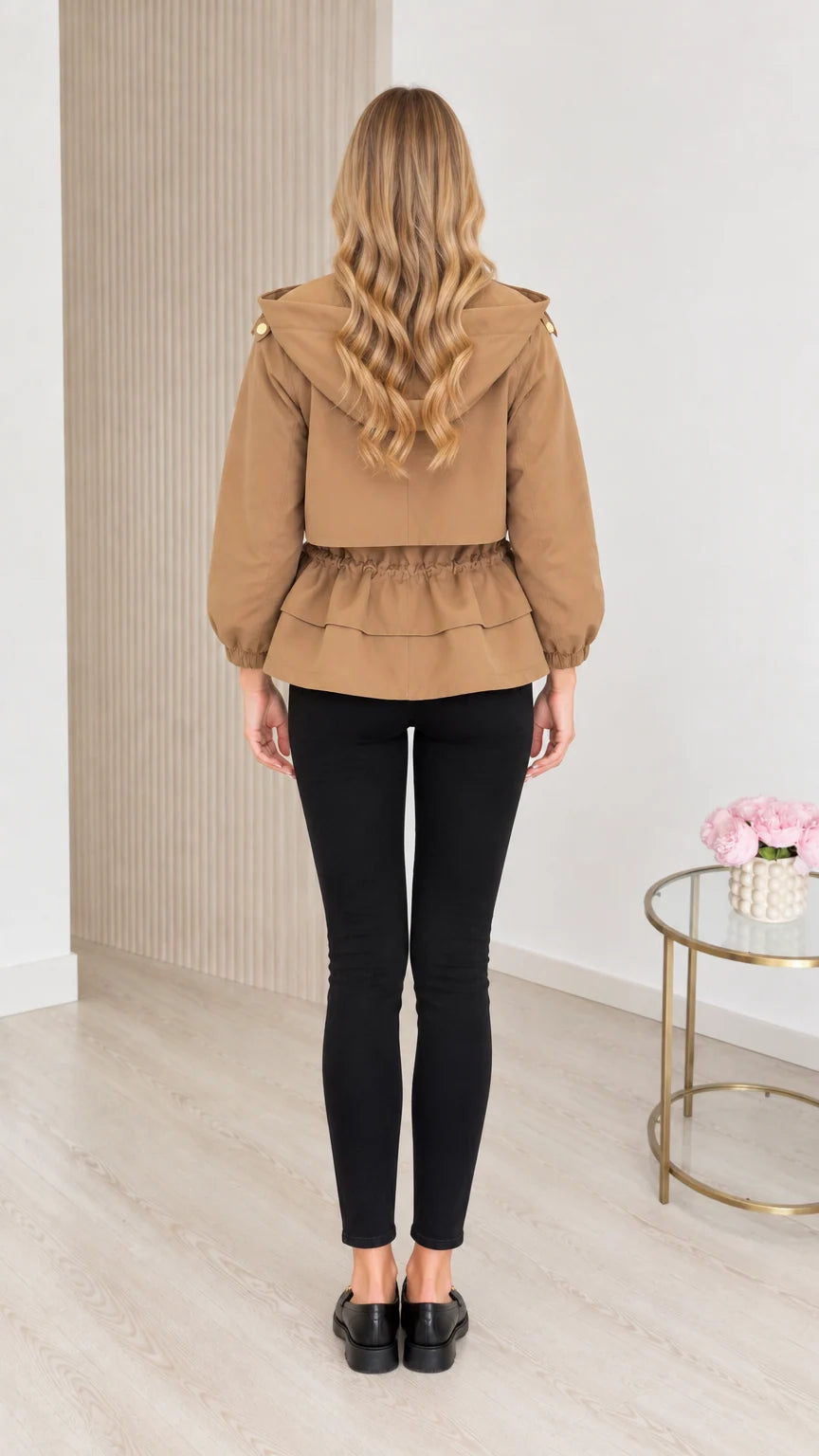 Back view of model wearing camel hooded utility jacket showing cinched waist detail