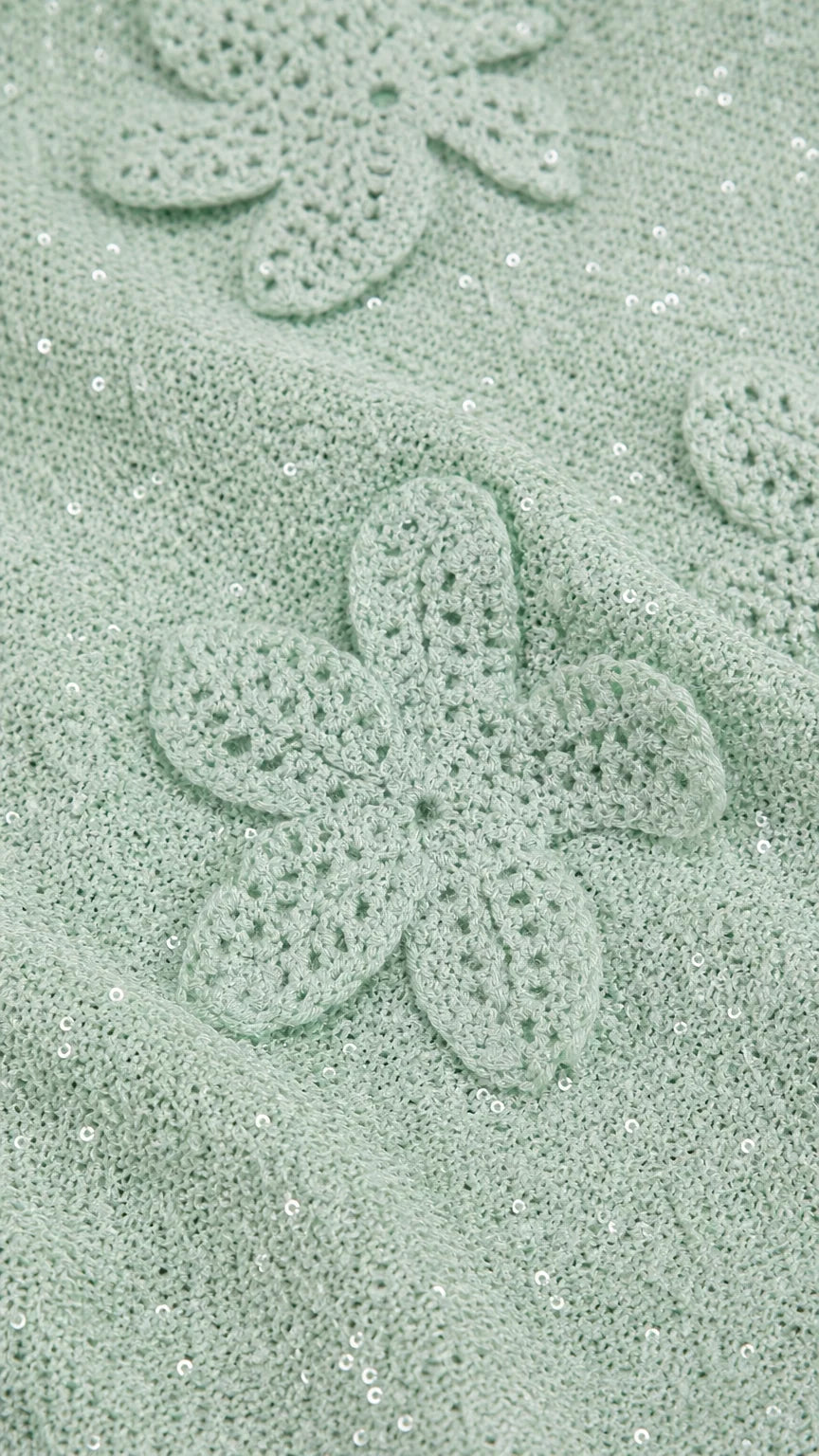 Close-up detail of mint green crochet floral applique and shimmer fabric