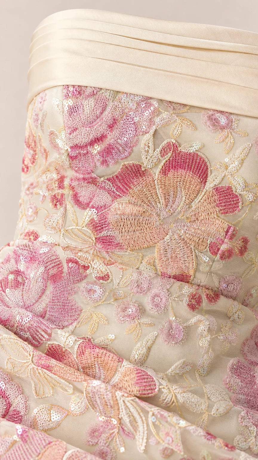 Close-up detail of floral embroidery and pleated bust trim on formal gown