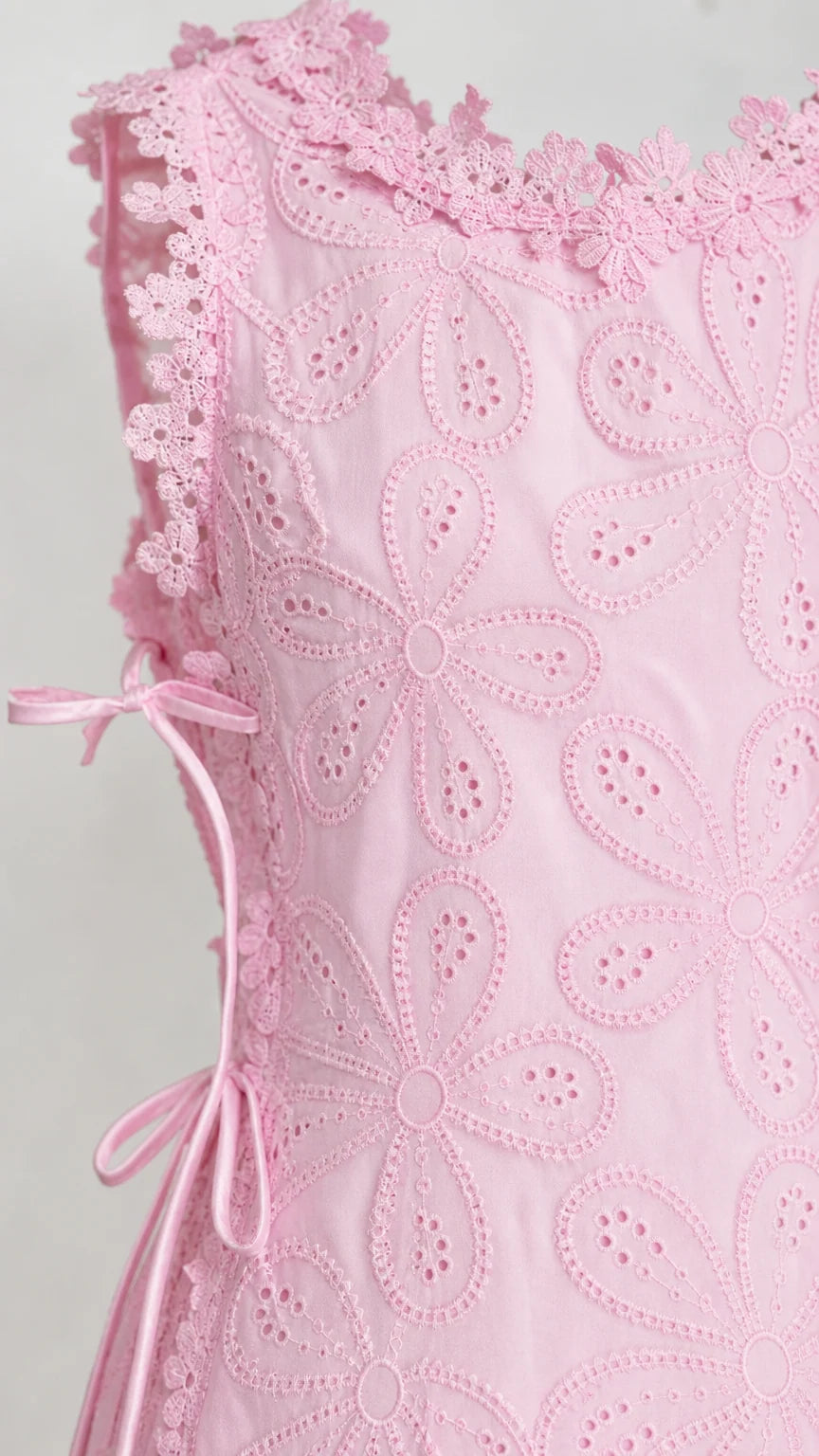Close-up detail of pink floral eyelet fabric and side tie