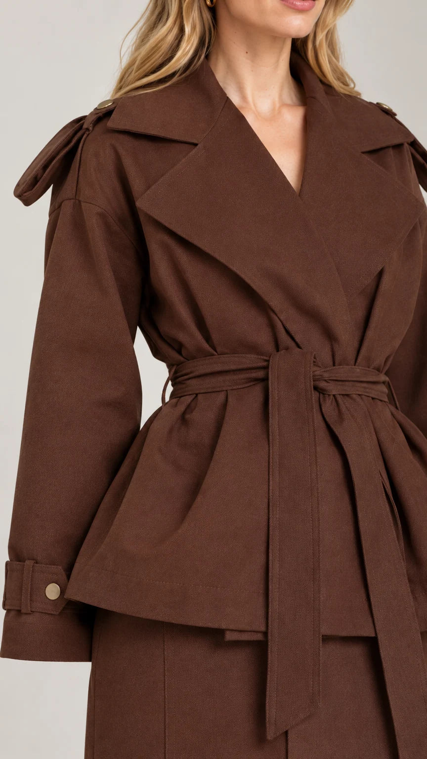 Close-up detail of chocolate brown trench-style lapel, tie belt, and cuff tabs
