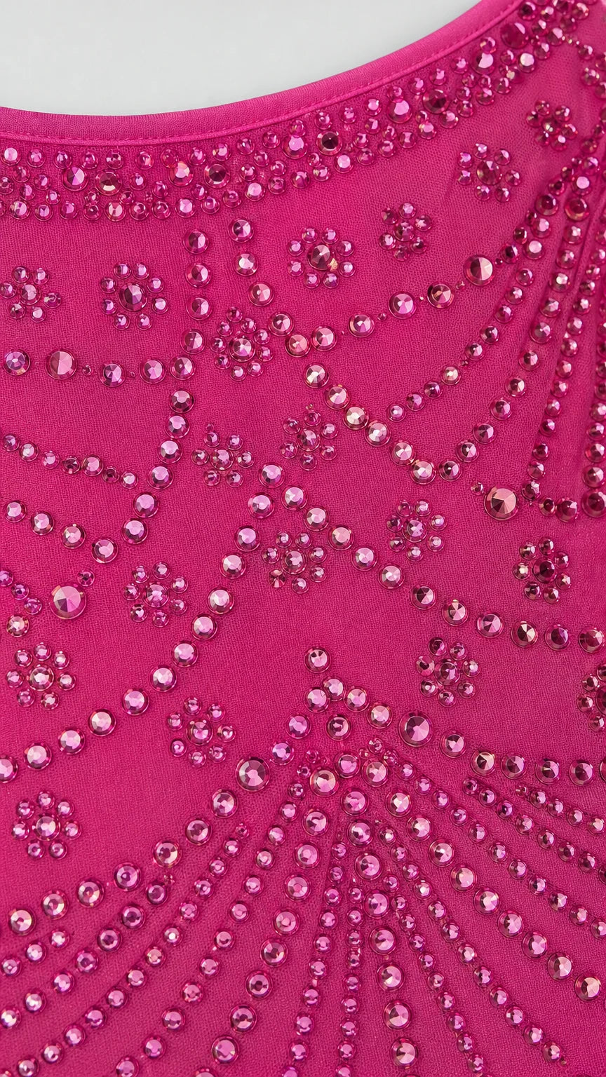 Close-up detail of rhinestone and bead pattern on hot pink fabric