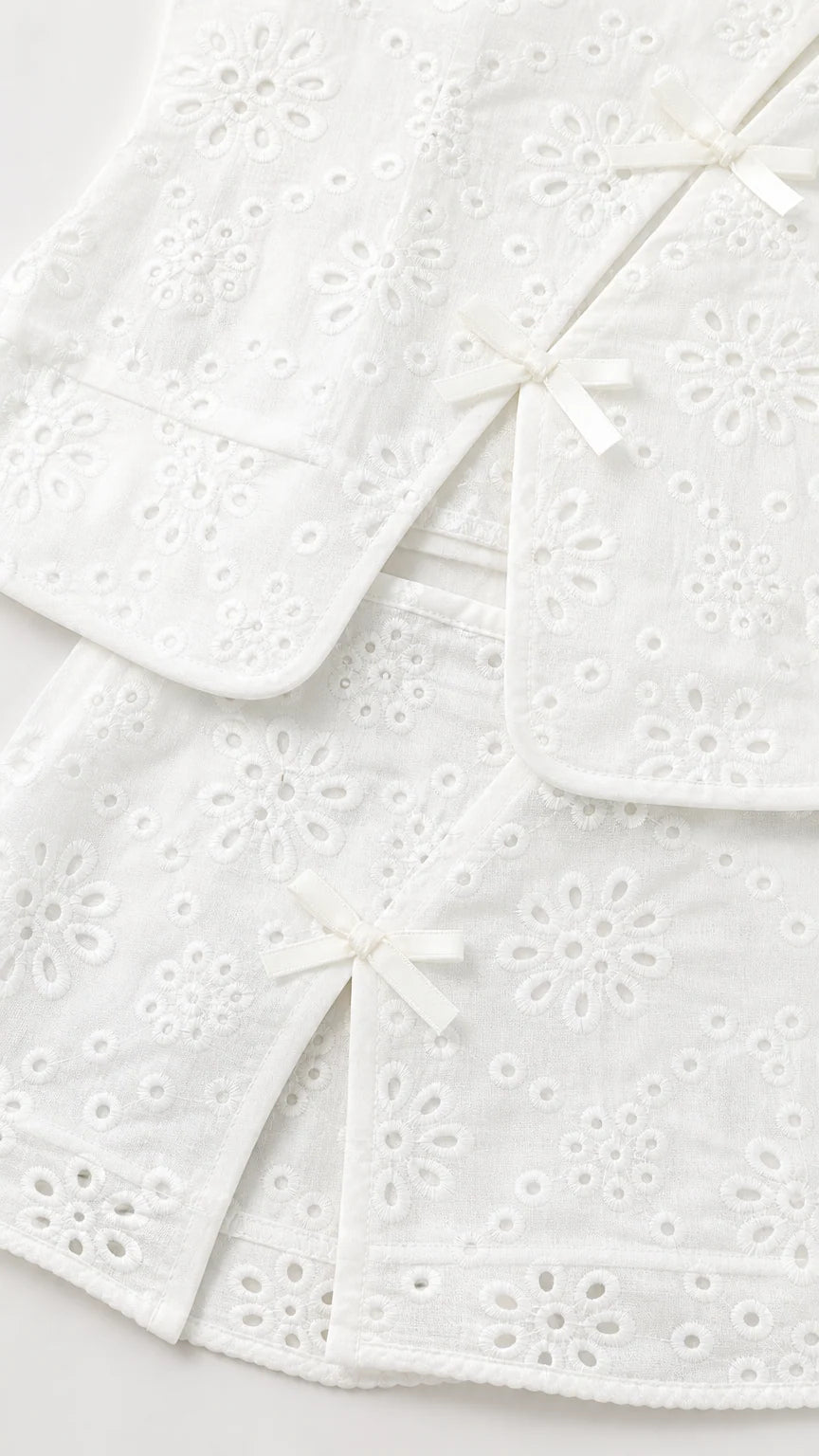 Close-up of white eyelet fabric and bow details